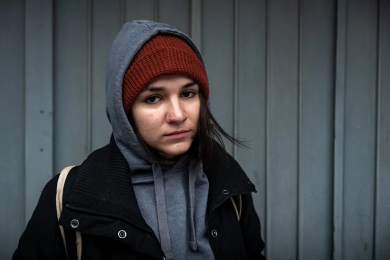 Young girl wearing red cap and grey hooded jacket