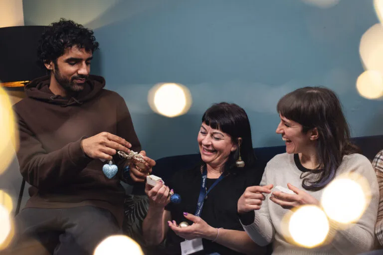 Staff and supported people hold Christmas decorations