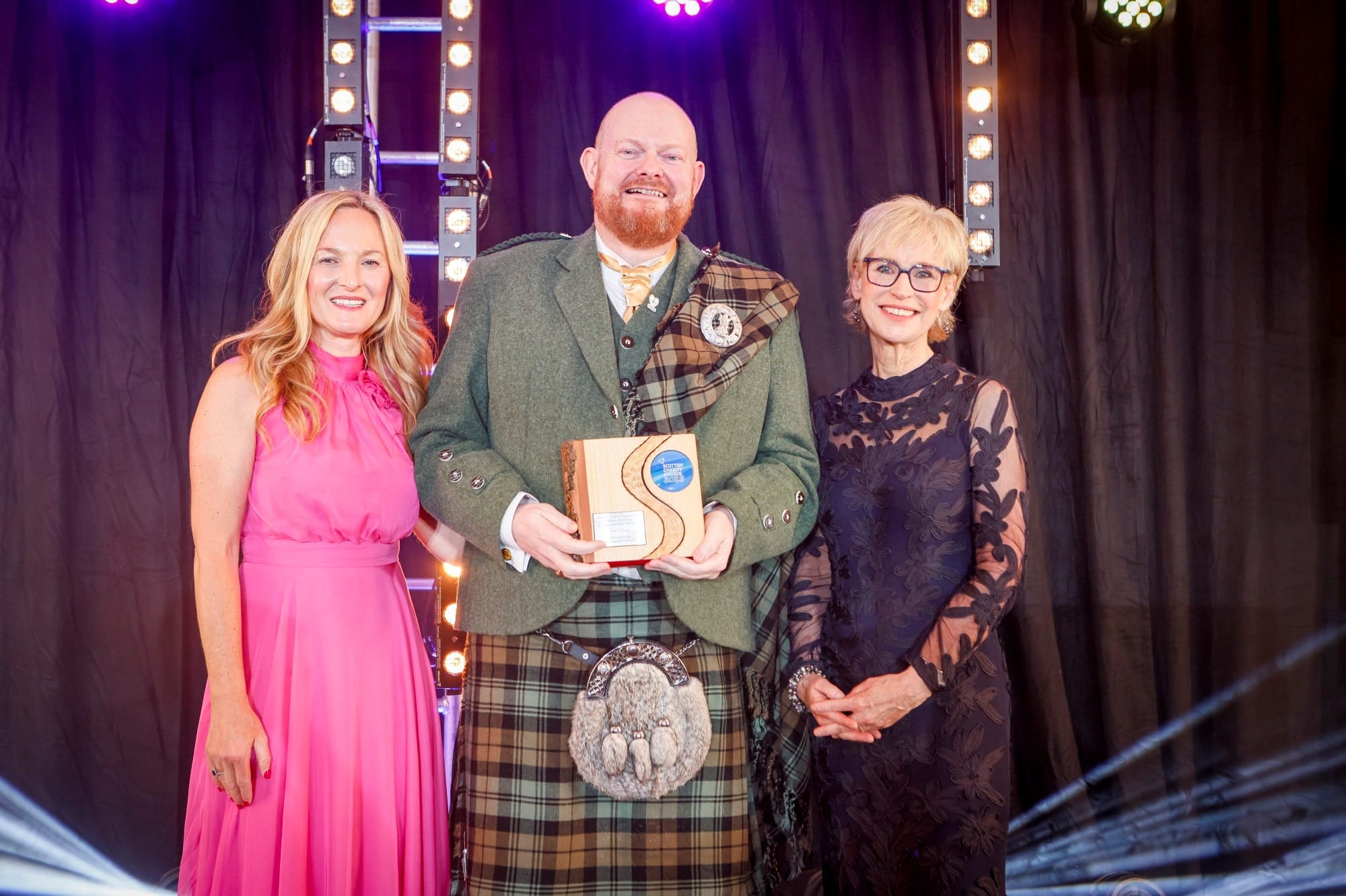 Gary Meek with award, beside presenters.
